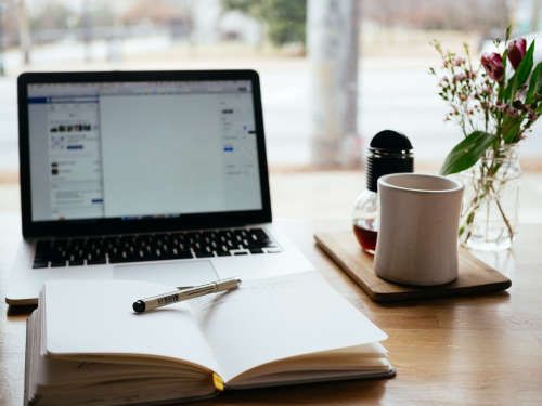 Writing on laptop and notepad